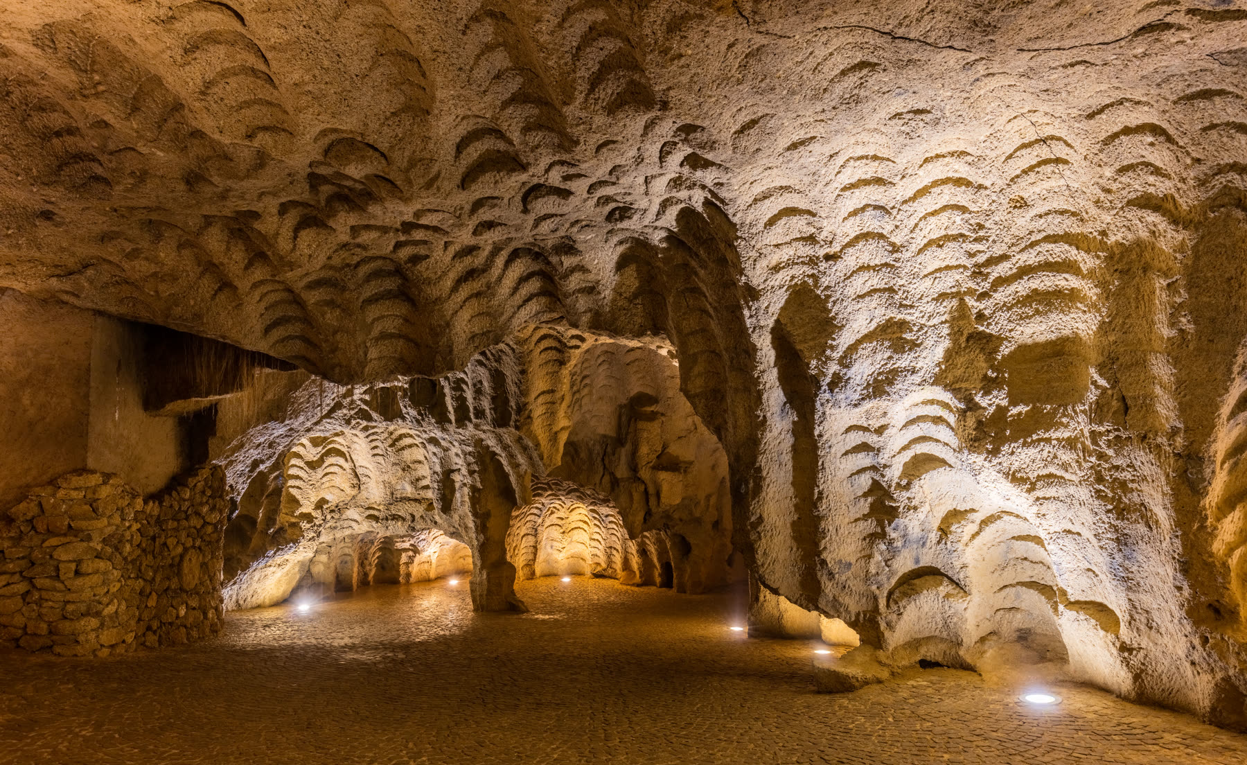 Wave-carved chamber walls inside the Caves of Hercules, shaped by centuries of Phoenician quern-stone quarrying