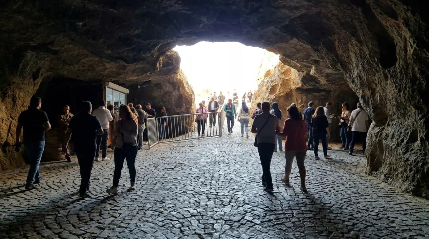 The interior ticket and information kiosk inside the Caves of Hercules entrance, with visitors gathered around